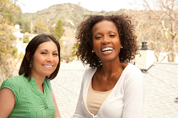 Two smiling women enjoying each other's company outdoors stock photo