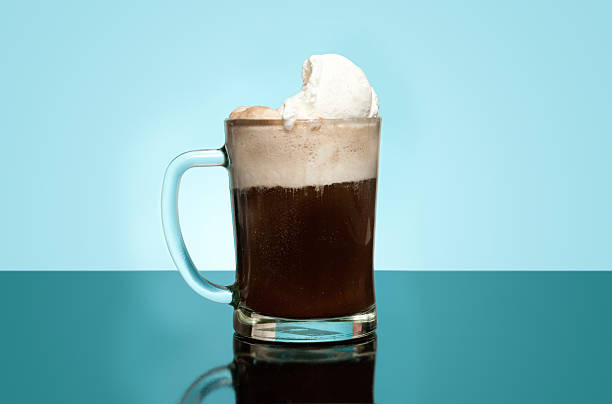 Layered Root beer float in a glass mug with dim blue back
