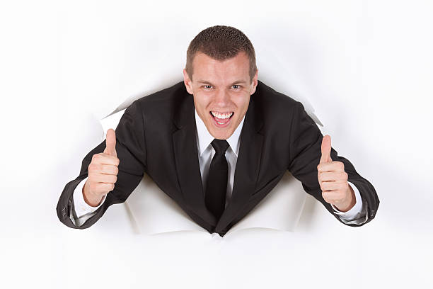 istock Businessman emerging through a hole in paper 184135049