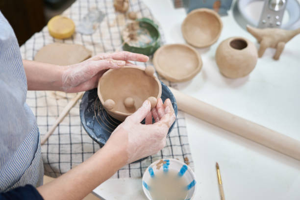 istock woman forming clay pot shape by hands, closeup in artistic studio 1841351511