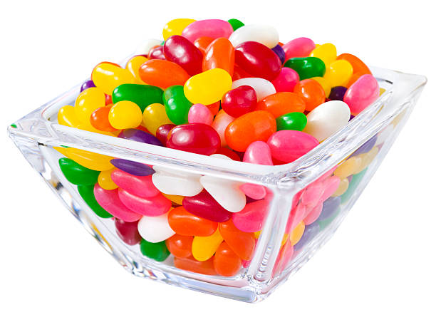 Pile of jelly beans in a candy bowl Jellybean sugar candy snack in a glass dish container isolated on white candy jellybean variation color image stock pictures, royalty-free photos & images