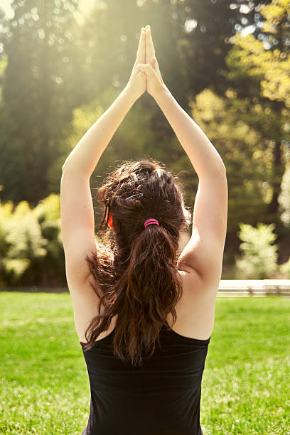 istock Young woman practicing yoga in the park 184135912