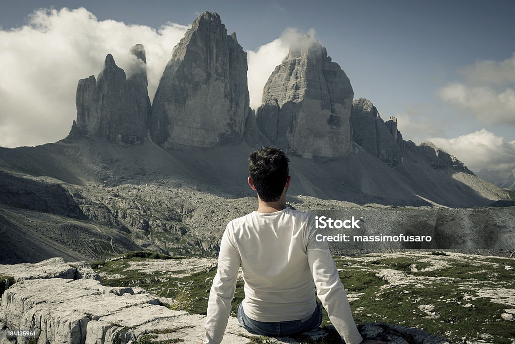 Man enjoying a view from top of the mountain A man enjoys a view of the mountains and the valley below and the clouds in the sky. Adult Stock Photo