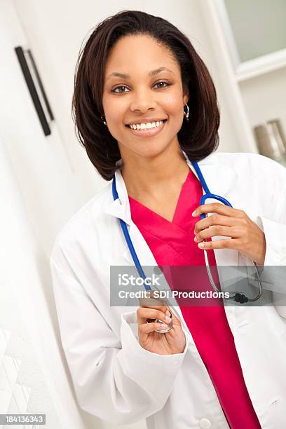 Glückliche Junger Arzt Stehend In Ihrem Büro Stockfoto und mehr Bilder von Afrikanischer Abstammung - Afrikanischer Abstammung, Allgemeinarztpraxis, Arbeiten