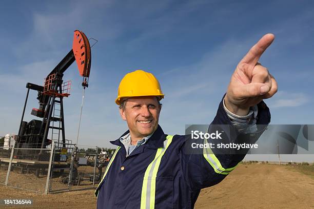 Operaio Addetto Allestrazione Di Petrolio Che Indica - Fotografie stock e altre immagini di Asfalto