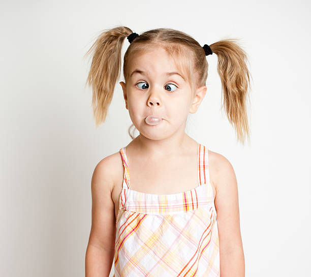 istock Girl Making Cross Eyes While Trying to Blow a Bubble 184136575