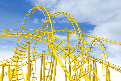 Yellow rollercoaster track with blue sky in the background.