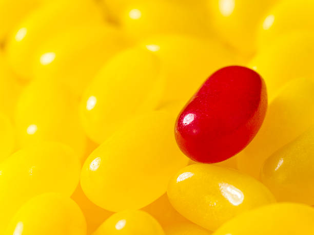 istock Red jellybean on a pile of yellow ones 184138021