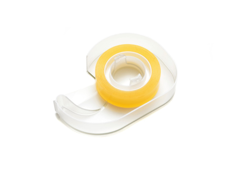 Close up of a tape dispenser on a white background.