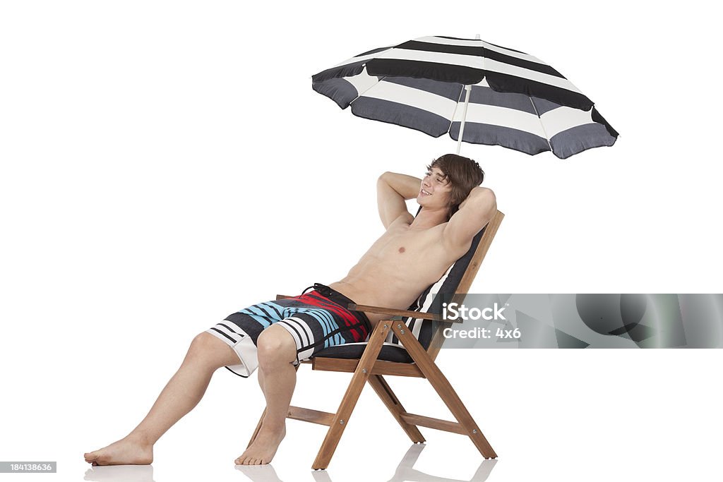 Hombre Descanse en una silla de playa - Foto de stock de Apoyarse libre de derechos