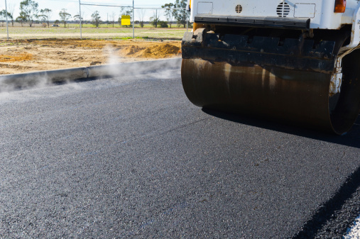 freshly laid asphalt being rolled and compacted