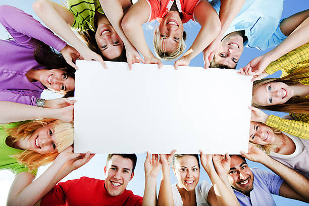 istock Group of people holding a big white board for advertisements. 184139092
