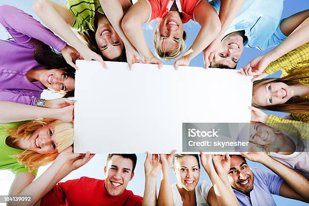 Group Of People Holding A Big White Board For Advertisements Stock Photo - Download Image Now