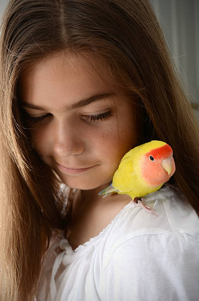 istock Girl with Lovebird on Her Shoulder 184139182