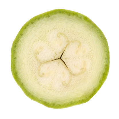 Zucchini circle portion on white background with interesting natural ornamental patterns. Clipping path included.Some vegetables from