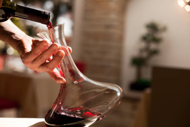 gießen wein aus der flasche - decanter wine wineglass red wine stock-fotos und bilder