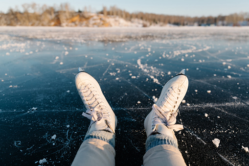 Skates close up on the ice of a frozen lake. Winter landscape, sunny day, atmosphere of fun winter activities