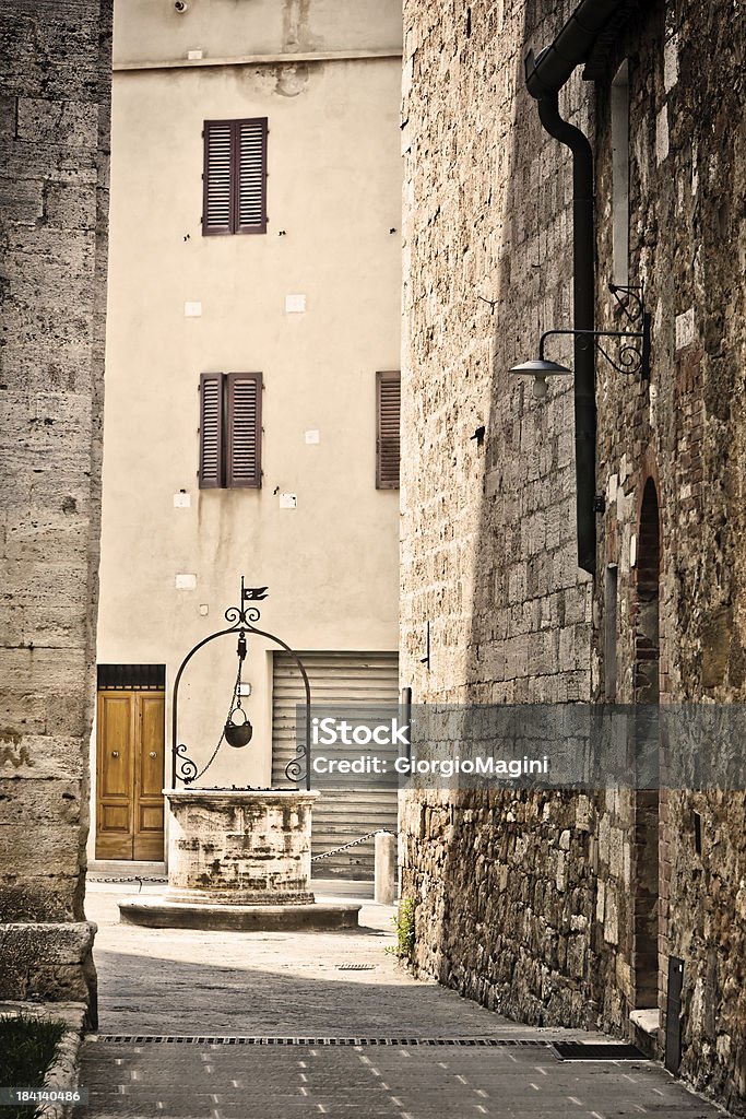 Beco com chão em San Quirico, aldeia de Val d'Orcia - Foto de stock de Aldeia royalty-free