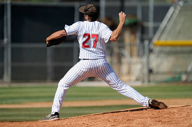 Baseball pitcher throwing the ball A baseball pitcher throws during a baseball game. baseball player stock pictures, royalty-free photos & images