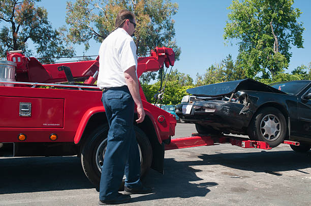 istock Tow Truck Driver Lifting a Wrecked Car 184140691