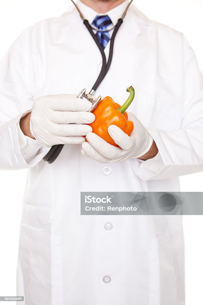 Doctor Examining Orange Bell Pepper Doctor examining an orange bell pepper with a stethoscope. Bell Pepper Stock Photo