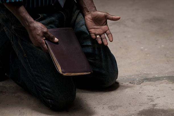 kneeling with bible stock photo