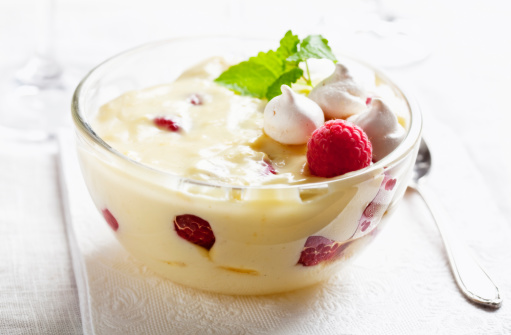 delicious vanilla pudding trifle with raspberries, with baiser, decorated with lemon balm