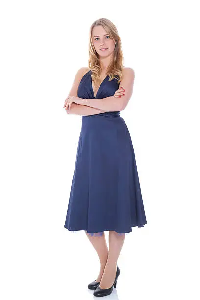 Studio shot of a teenage girl stnading in a blue ballgown with her arms folded - isolated on white.