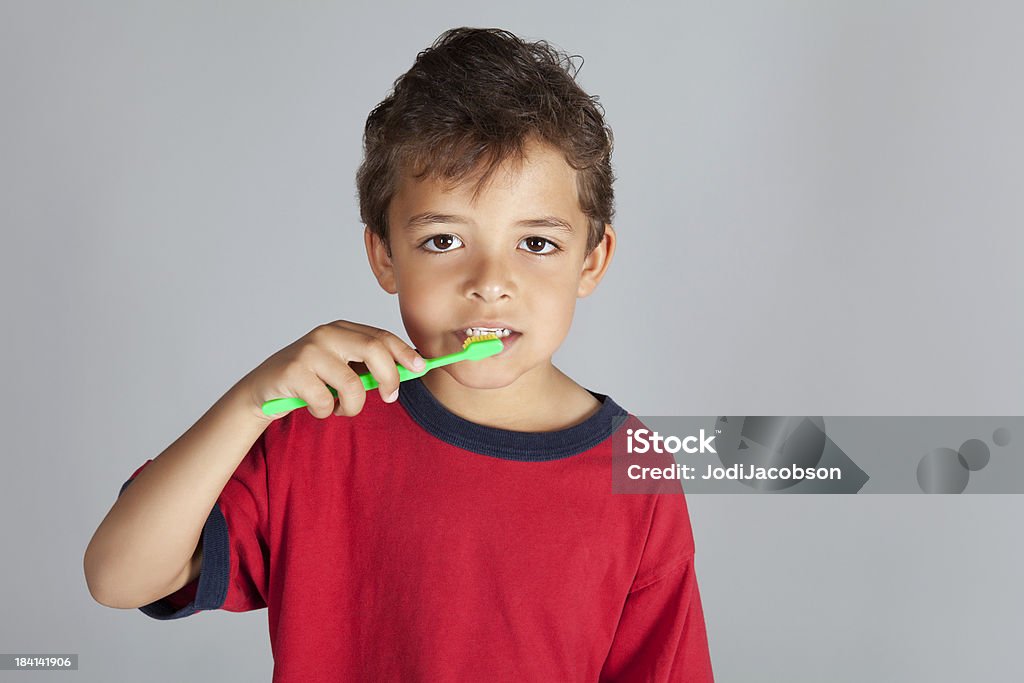 Young boy ブラッシング彼の歯、緑色の歯ブラシます。 - オレンジ色のロイヤリティフリーストックフォト