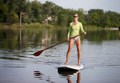 Stand up paddling on a calm lake.