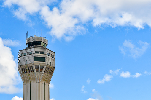Airport traffic control tower with clouds and blue sky background