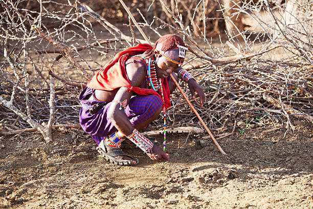 istock Young maasai examining the ground for tracks. 184143381
