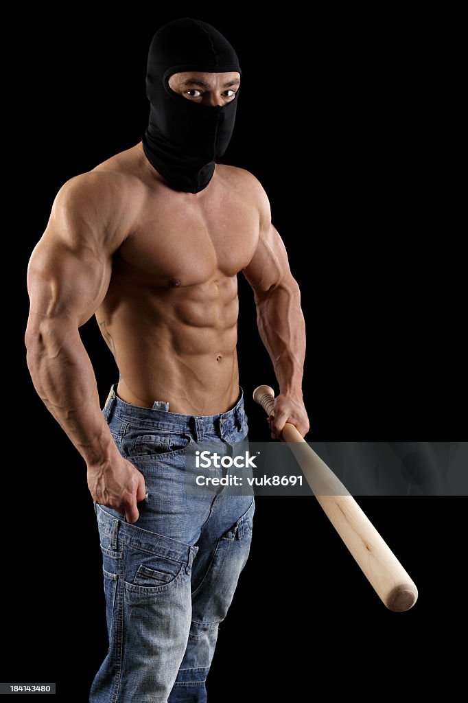 Dangerous guy Young hooligan with baseball bat-isolated on black background Adult Stock Photo