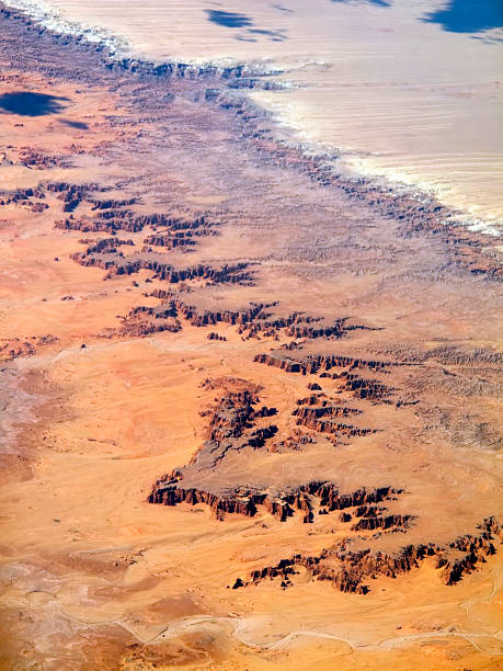 aerial badlands landscape "desert badlands and rock formation pinnacles sprawl out in oranges, yellows, reds, and browns bringing texture to the landscape.  vertical composition taken in new mexico with selective focus on foreground." sonoran desert desert badlands mesa stock pictures, royalty-free photos & images