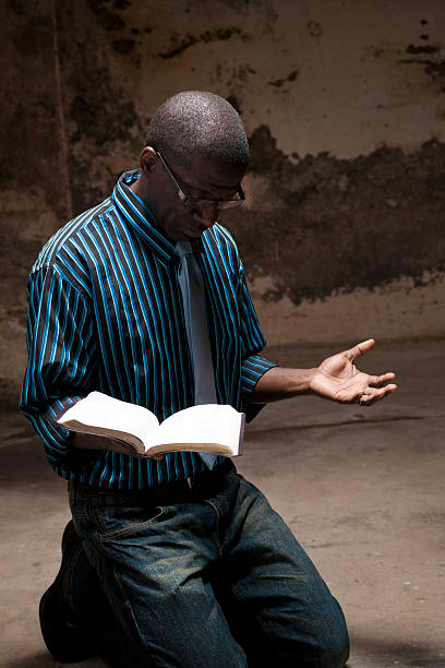 kneeling in prayer stock photo