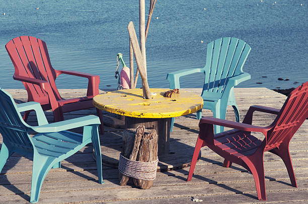 A table and four chairs on the end of a pier.