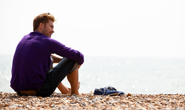 Handsome British fellow sitting on the beach in Brighton