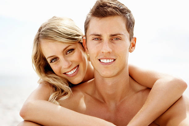 istock Young couple embracing on the beach 184145594