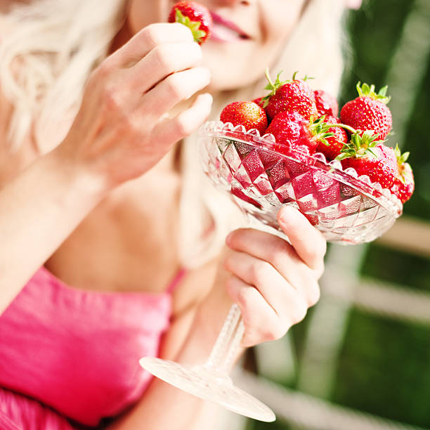istock woman eating strawberries 184146085