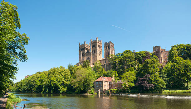 Durham Cathedral, Fulling Mill and River Wear, UK "Durham Cathedral is renowned as a masterpiece of Romanesque (or Norman) architecture. It was begun in 1093 and largely completed within 40 years. The Cathedral is built on a strategic peninsula of land created by a loop in the River Wear and its west end towers over a precipitous gorge. Together with its neighbour Durham Castle, the cathedral is now a World Heritage Site. The Old Fulling Mill next to a weir on the river, dates mostly from the 15th Century and played a key part of Durham's cloth-making industry. Image taken late on a bright summers day with plenty of space for copy and text. ProPhoto RGB profile for maximum color fidelity and gamut.More of my images from around Britain in this lightbox:" norman uk tree sunlight stock pictures, royalty-free photos & images