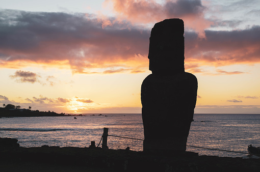 Silhouette of lonely moai at sunset near the marina of Hanga Roa