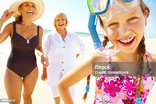 Foto de Criança Usando Máscara De Mergulho Com A Família Aproveitando Na Praia e mais fotos de stock de Praia