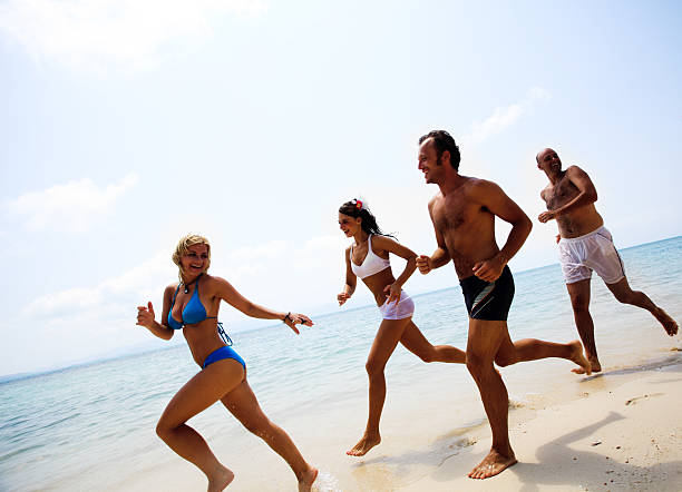 istock Group of young people running at the beach. 184147009
