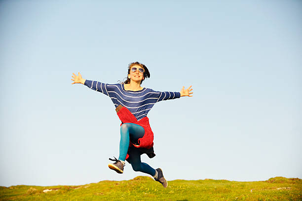 istock Girl Jumping Over Meadow 184147250