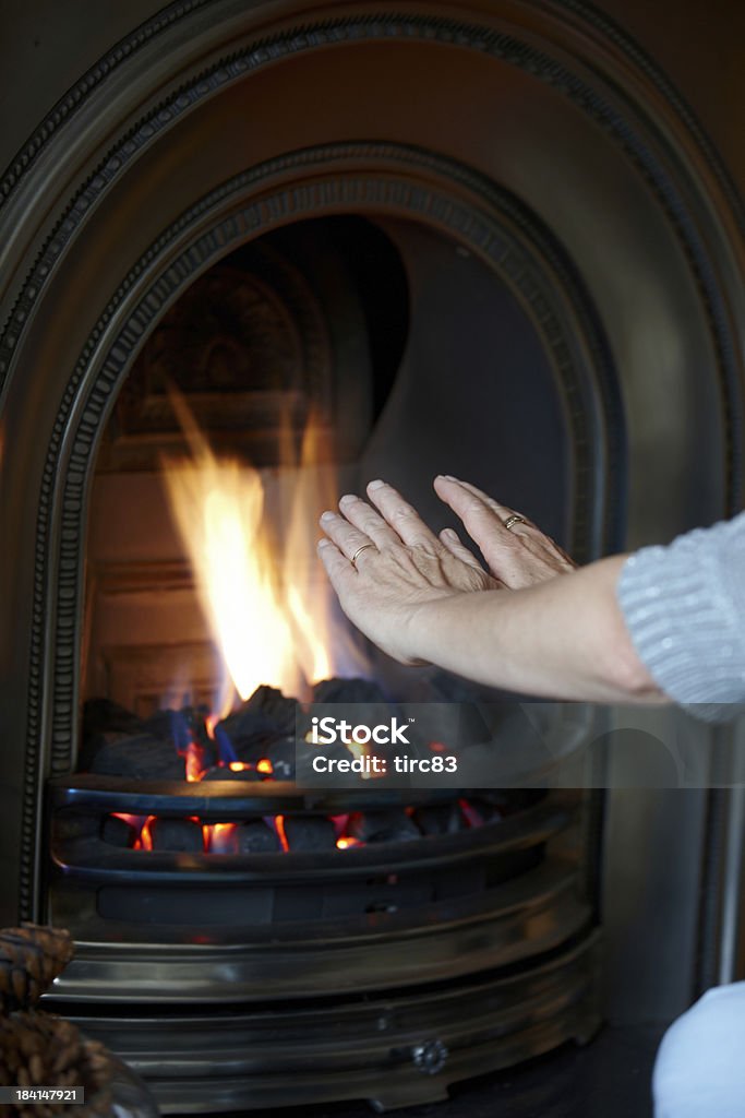 Donna matura da carbone fuoco riscaldamento le mani - Foto stock royalty-free di Adulto