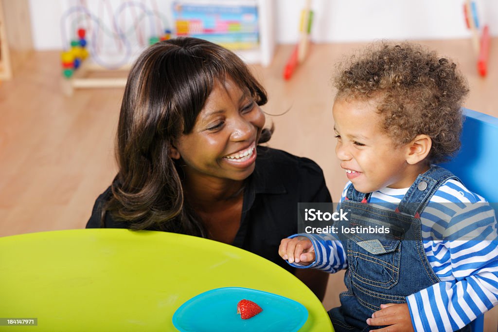 Kindermädchen/Pflegekraft/und Kleinkinder einen glücklichen Moment Zeit, während der Mahlzeiten - Lizenzfrei Kindermädchen Stock-Foto