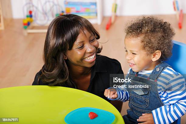 Foto de Raciocínio Cuidador E Bebê Desfrutando De Um Momento Feliz Durante As Refeições e mais fotos de stock de Babá