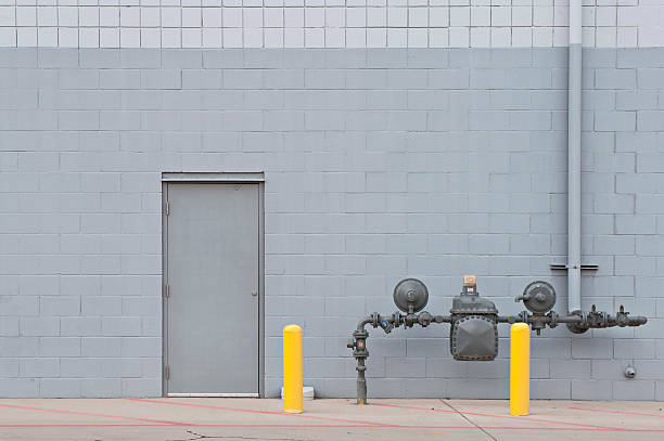 Industrial Utility Door on Brick Wall Utility door on gray brick wall store wall surrounding wall facade stock pictures, royalty-free photos & images