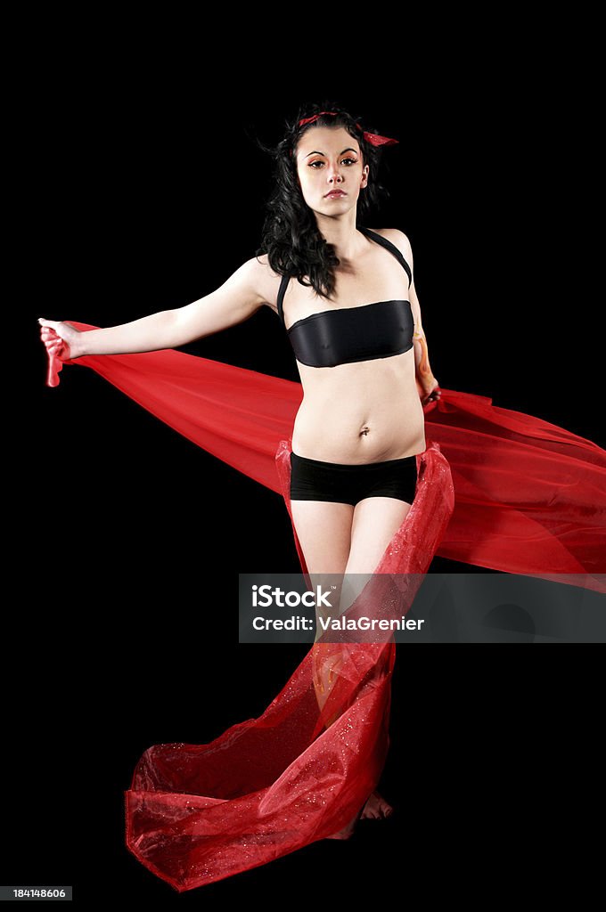 Fire nymph dancing with red fabric. Young woman as fire nymph with red fabric.  Vertical studio shot on black. 20-29 Years Stock Photo