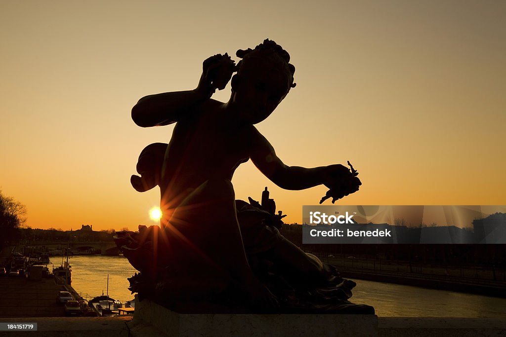 Paris Sunrise, France "Silhouette of child figure on the Pont Alexandre III at sunrise in Paris, France.Pont Alexandre III is an arch bridge that spans the Seine, widely regarded as the most ornate, extravagant bridge in Paris." Back Lit Stock Photo